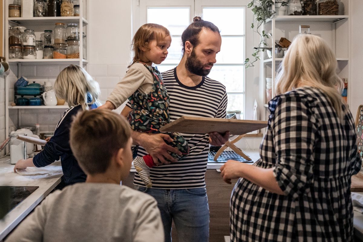 Eine fünfköpfige Familie drängt sich in der Küche bei der Vorbereitung des gemeinsamen Abendessens